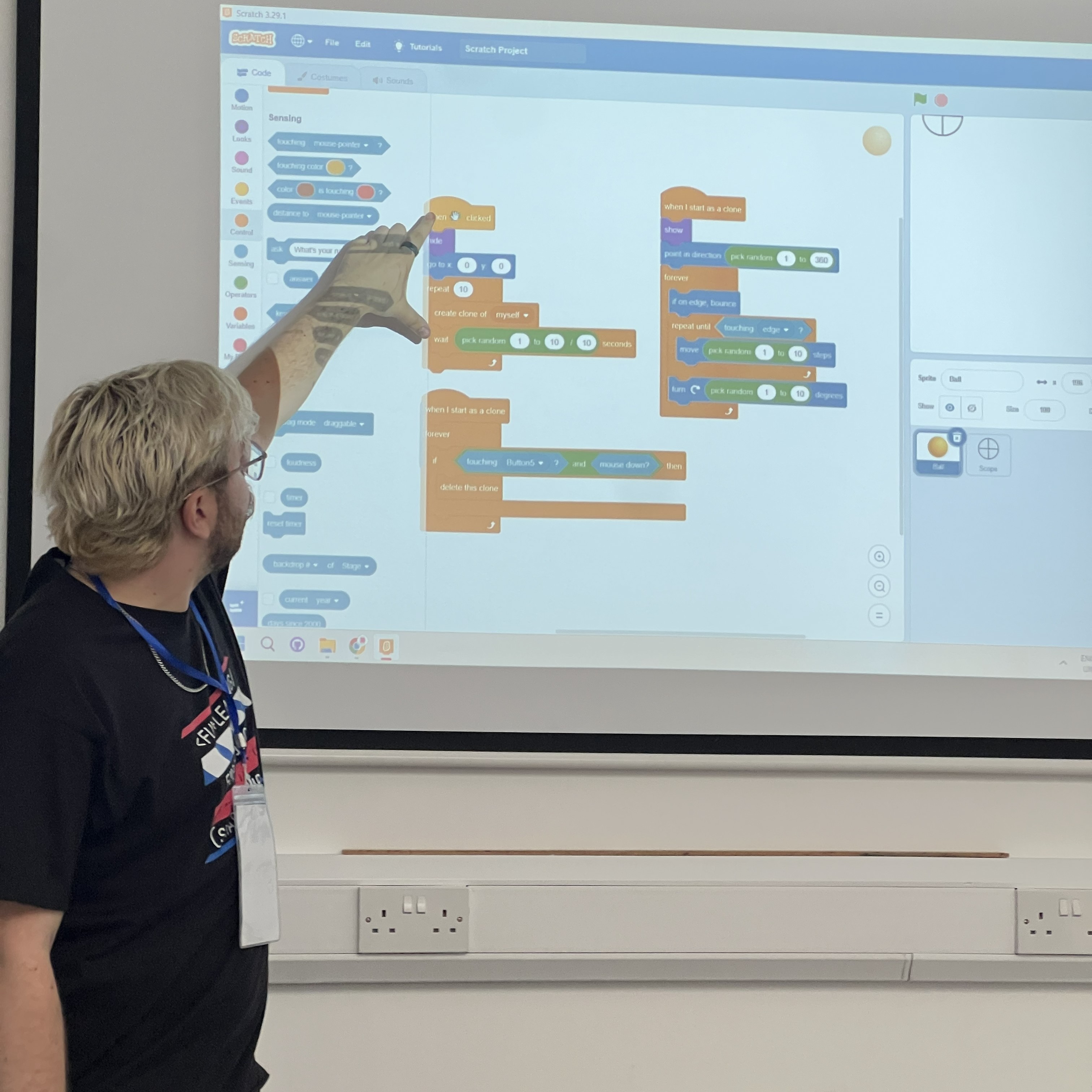 Jack pointing at a Scratch project on a classroom whiteboard